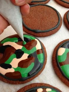 someone is decorating cookies with camouflage designs