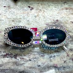 Brand New Pair Of Rhinestone Sunglasses Hand Jeweled By Me. Rhinestones Are Clear Swarovski With A Huge Swarovski A Crystal On The Bridge. You’ll Get A Few Extra Stones In Case Of Any Mishaps, But They Are Securely Glued With Industrial Glue And Sparkle Like Crazy In The Sun. Amazing For Summer And Festival Season Party Sunglasses With Rhinestones And Crystal Material, Party Crystal Sunglasses With Rhinestones, Glamorous Silver Sunglasses With Glass Lenses, Glamorous Silver Glass Sunglasses, Silver Rhinestone Sunglasses With Glass Lenses, Silver Rhinestone Sunglasses With Glass, Silver Sunglasses With Rhinestones, Trendy Crystal Sunglasses With Rhinestones, Trendy Rhinestone Crystal Sunglasses