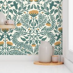 a white shelf sitting next to a vase on top of a counter in front of a wall