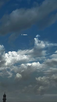 an airplane is flying in the sky with some clouds behind it and a clock tower