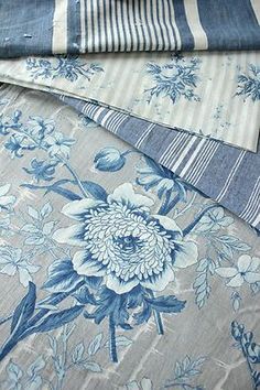 four different types of blue and white fabric on top of each other, all with flowers