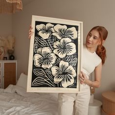 a woman holding up a black and white flower print