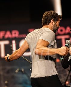 two men standing next to each other holding microphones