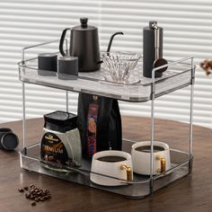 a tray with coffee cups and other items on it sitting on top of a wooden table