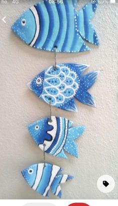 three blue and white fish hanging on a wall