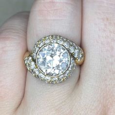 a woman's hand with a diamond ring on top of her finger and an engagement band