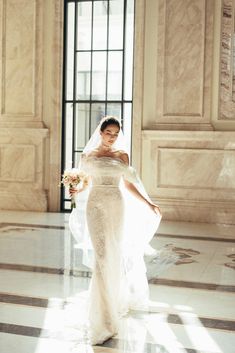 a woman in a wedding dress is posing for the camera