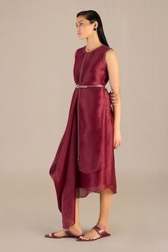 Maroon sleeveless midi dress with metallic embellishments detailing and a cowl draped asymmetric hem. Paired with a matching three fourth sleeves long jacket and a co-ordinating belt. - Aza Fashions Chic Draped Festive Dress, Chic Draped Dress For Festive Season, Chic Festive Draped Dress, Festive Sleeveless Midi Dress, Festive Formal Sleeveless Midi Dress, Silk Dress With Asymmetrical Hem For Festive Occasions, Festive Silk Dress With Asymmetrical Hem, Cowl Drape Dress, Embellishment Details