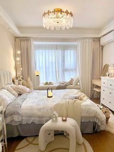 a bed room with a neatly made bed and a chandelier hanging from the ceiling