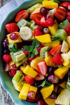 a fruit salad with kiwis, strawberries, grapes, and bananas in a blue bowl