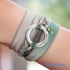 "This Steel and Silk Wrap bracelet features a Steel ring with an engraving that reads \"one day at a time.\" The ring measures 20 mm (approximately .75 inches) in diameter and is attached to silk ribbon that measures 38 inches (approximately 96.5 cm) in length. The hand dyed silk ribbon is sewn on the edge to prevent fraying and attached with Sterling Silver wire. Silk Wrap Bracelets are easy to wear. Just wrap the silk ribbon around your wrist, slide the ring where you want it, and tie the ribb Silk Wrap Bracelets, Health Bracelet, Bohemian Wrap, Hand Dyed Silk Ribbon, Silk Bracelet, Boho Wrap Bracelet, Inspirational Bracelets, Ribbon Wrap, One Day At A Time