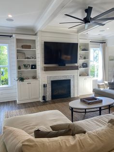 a living room filled with furniture and a flat screen tv mounted on the wall above a fireplace