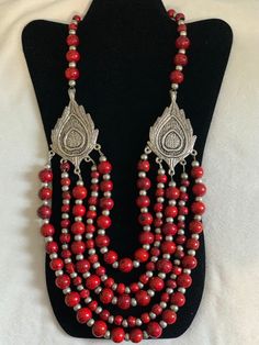 A bright and gorgeous statement peace made with German Silver Leaf Pendants and five strands of bold red beads. It is approximately 14 inches long. Red Polished Beads Beaded Necklace For Festival, Red Polished Bohemian Beads, Red Multi-strand Dangling Beads, Multi-strand Red Necklace With Colorful Beads, Festive Red Coral Necklace, Red Wooden Beaded Necklaces, Red Multi-strand Beaded Necklaces With Large Beads, Red Coral Beaded Necklace With Wooden Beads, Red Multi-strand Beaded Necklace With Large Beads