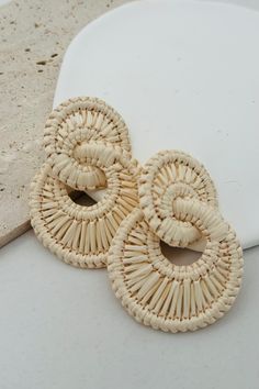 These unique earrings feature double hoops made from woven raffia straw, creating a playful and statement-making look. Perfect for adding a touch of quirkiness to any outfit, these earrings are sure to turn heads and showcase your personality! Post Back Iron frame Raffia Straw 2.25" Length 1.75" Width Rafia Crafts, Raffia Macrame, Raffia Crafts, Macrame Wedding Decor, Straw Accessories, Raffia Earrings, Rope Earrings, Straw Earrings, Macrame Hoop