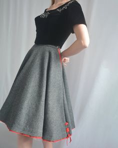 This classic 1950s circle skirt is crafted from a gorgeous quality wool felt. Its heather grey color is accented by peekaboo red trim, including lace-up details at the hem. It was made by Saks Fifth Avenue "The Young Circle" label. It has pockets on either side! It is shown both with and without a crinoline petticoat- you could even wear an even fuller one for that exaggerated 1950s look, but it also looks perfect worn solo. It closes with a zipper and button at side waist. No fiber contents are 1950s Circle Skirt, 1950s Interior, 1950s Look, 1950s Skirt, Velvet Corset, Corset Bodice, Velvet Top, Wool Skirt, Designer Vintage