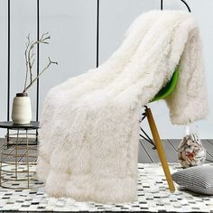 a white blanket sitting on top of a wooden chair