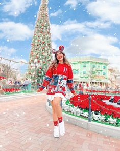 a woman is walking in front of a christmas tree at universal studios'holiday wonderland