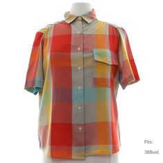 "80s \"rrrruss\" Womens multi color background polyester cotton blend short sleeve button up front shirt. Blocked plaid in shades of red, turquoise, gold, and hazy orange, red and grey, ruched shoulders. Fold over collar, single flap pocket with button closure and slightly rounded hemline. Fits: 38Bust Our item # 362914" Plaid Relaxed Fit Camp Shirt For Summer, Relaxed Fit Plaid Camp Shirt For Summer, Summer Plaid Button-up Short Sleeve Shirt, Retro Multicolor Short Sleeve Shirt For Spring, Casual Plaid Camp Shirt For Summer, Summer Plaid Short Sleeve Camp Shirt, Retro Multicolor Short Sleeve Shirt, Multicolor Retro Short Sleeve Shirt, Vintage Multicolor Short Sleeve Shirt For Summer