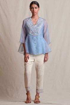 Powder blue floral motif adorned tunic with crepe inner.
Components: 1
Work: Resham Thread,Cutdana Embroidery
Neckline: V Neckline
Color: Blue
Fabric: Organza,Crepe
Sleeve: Three Quarter Sleeves
Other Details: 
Front Loop Button Closure
Note: Pant worn by the model is not for sale - Aza Fashions Silk V-neck Top With Embroidery, Elegant V-neck Kurta With Floral Embroidery, Elegant Embroidered Neckline Tunic For Summer, Elegant Summer Tunic With Embroidered Neckline, Silk Embroidered Top With Intricate Embroidery, Elegant Designer Straight Kurta Blouse, Elegant V-neck Festive Tunic, Elegant Festive V-neck Tunic, Eid Georgette Blouse With Resham Embroidery