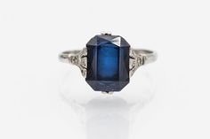 Vintage ring made of 18-carat white gold. Its centerpiece is a faceted, rectangular synthetic sapphire weighing approximately 4.00 carats. Sapphire is distinguished by its beautiful, deep blue color. Synthetic sapphire means that it was created by humans in laboratory conditions and has the same chemical and physical properties as natural sapphire. The synthesis of sapphires began at the beginning of the 20th century and became very popular. Origin: France, second half of the 20th century. Prese Classic Octagon Sapphire Ring With Diamond, Fine Jewelry White Gold Square Cut Sapphire Ring, White Gold Square Cut Sapphire Ring, White Gold Sapphire Ring With Square Cut, Square Cut Sapphire Ring In White Gold, Square Cut Sapphire Ring With Diamonds For Formal Occasions, Square Cut White Gold Sapphire Ring, Formal Square Cut Sapphire Ring, Octagon Sapphire Diamond Ring