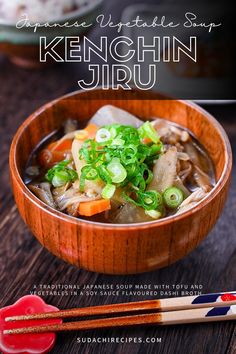 a wooden bowl filled with soup next to chopsticks on top of a table