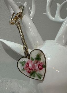 a heart shaped porcelain keychain with flowers on it's front and back