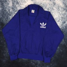 "Details: Vintage blue training sweatshirt by Adidas. White trefoil logo printed on the front and back. Condition: Good Signs of wear: N/A Size: XS Measurements: Length - 23.5\" Pit to Pit - 21\" Shoulder to cuff - 22\"" Sporty Logo Tops For College, Blue Sportswear Top With Three Stripes Branding, Blue Sports Top With Three Stripes Branding, Blue Sports Tops With Three Stripes Branding, Blue Logo Sweatshirt For Streetwear, Adidas Logo Cotton Sweatshirt In Athleisure Style, Adidas Logo Cotton Sweatshirt For Athleisure, Blue Adidas Athleisure Top, Adidas Logo Sportswear Sweatshirt For Sports Season