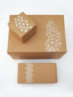 two boxes with designs on them sitting next to each other and one box has a piece of paper cut out of it