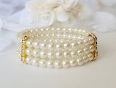 This 3 row stretch bracelet is made with 8 mm ivory glass pearls and gold plated crystal rondelles.  Perfect for you or your bridesmaids. This stretchy pearl bracelet measures approximately 7 inches (17,7 cm) long. Please specify if you need a different size at checkout.  All items are handmade by me! Elegant Pearl Stretch Bracelet For Wedding, Bridesmaid Pearl Bracelet, Pearl Bracelet Gold, Pearl Cuff Bracelet, Pearl Cuff, Bridesmaid Pearls, Bracelet Pearl, Wedding Jewelry Bracelets, Bridal Shower Gift