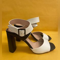 Whether You Choose To Dress Them Up Or Down, These Sleek Vegan Leather Single-Sole Block Heels Will Stun With Their Contrasting White Toe Strap And Adjustable Ankle Strap. Style Yours With Anything And Everything As These Sandals Will Always Look Versatile. Heel Height 4 2334 White Leather Heels With Buckle Closure, White Leather Heels With Contrasting Heel Counter, White Ankle Strap Heels For Work, Chic White Sandals With Buckle Closure, White Block Heel Workwear Heels, White Block Heel Shoes For Work, White Round Toe Sandals For Office, White Heels With Heel Strap For Work, White Round Toe Heels For Work