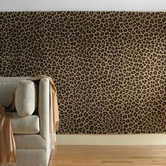 a living room with a couch, chair and leopard print wallpaper