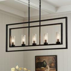 a chandelier with five lights hanging from it's center piece in a dining room