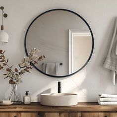 a bathroom with a round mirror above the sink