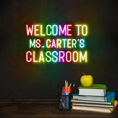 a neon sign that says welcome to ms carter's classroom with books and an apple