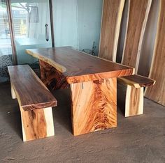 two wooden benches sitting next to each other in front of a glass wall and door