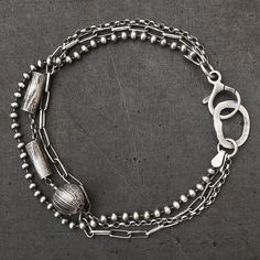 - Light and delicate layered chain bracelet - Made entirely of oxidised (darkened and polished) sterling silver (925) - 3 different chain styles - Hammered silver circle - Reticulated silver tubes and ball - All links soldered for extra strength - Lobster clasp fastening - Great for everyday wear and special occasions - Handmade to order - Tube dimensions: 0.16 x 0.40 inch (4 x 10 mm) - Ball diameter: 0.31 inch (8 mm) - Weight: approx. 7g Total length - 6 options:  6.5 inches (15.6 cm) 7 inches (17.8 cm) 7.5 inches (19 cm) 8 inches (20.3 cm) 8.5 inches (21.6 cm) 9 inches (22.9 cm)  or please let me know if you require a different length. Postage & Packaging: United Kingdom: Royal Mail 1st class Delivery time: usually 1-2 working days Worldwide: International Standard  Delivery time: 7-9 wo Cuff Bracelets Handmade, Layered Chain, Multi Strand Bracelet, Sterling Bracelets, Layered Chains, Silver Circle, Strand Bracelet, Hammered Silver, Multi Strand