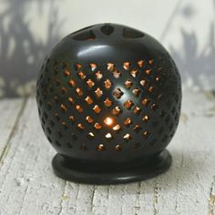 a black candle holder sitting on top of a wooden table