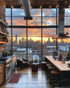 an open kitchen and living room with a view of the city at sunset or dawn