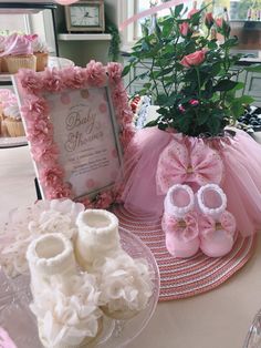 a table with baby shoes and flowers on it