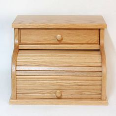 a wooden drawer with two drawers on the bottom and one drawer at the top, against a white wall