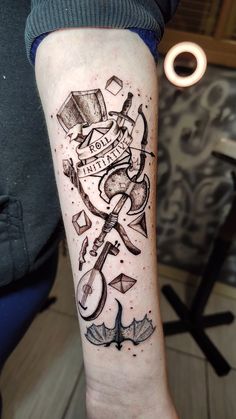 a person with a tattoo on their arm that has scissors and other things on it