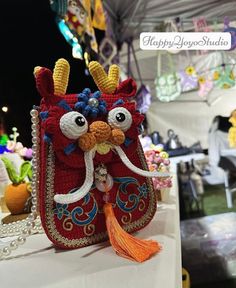 a red purse with horns and tassels sitting on top of a white table