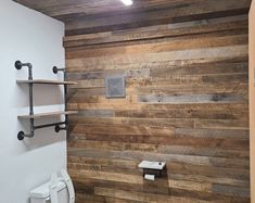 a bathroom with wooden walls and toilet paper dispenser on the wall next to it