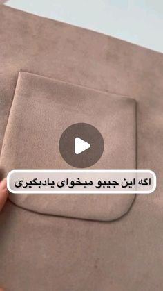 someone is holding up a piece of fabric with the words in arabic and english on it