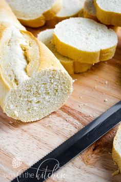 sliced loaf of bread sitting on top of a wooden cutting board next to a knife