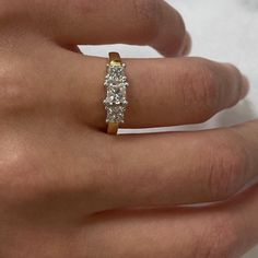 a woman's hand with a three stone ring on it