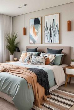 a bedroom with a large bed and two paintings on the wall above it's headboard