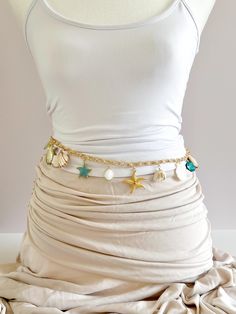 Gold plated belly waist chain featuring assorted coastal charms -- natural seashells, gemstones, mother of pearl, and gold plated Lobster clasp 32" total, adjustable length Can be adjusted to accommodate smaller waist sizes by latching clasp onto smaller links This waist chain can be styled as shown and also doubles as a long charm necklace! All pre-made styles are sold as is and not modifiable. If you wish to change any charms on a necklace, it would be considered a custom order. If you have qu Seashell Waist Chain, Beach Shell Charms Jewelry, Seashell Belt, Mermaid Accessories, Gold Body Chain, Custom Charm Bracelet, Waist Jewelry, Custom Charm Necklaces, Mermaid Jewelry