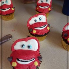 cupcakes with cars on them sitting on a table