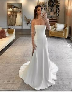 a woman is taking a selfie in her wedding dress while standing on the floor